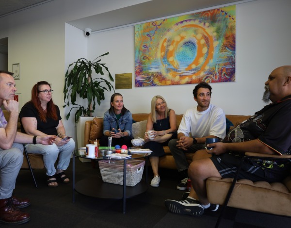 A group of people sitting around a coffee table and talking