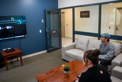 two people sitting on couches in a living room