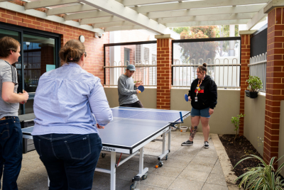 four people playing ping pong