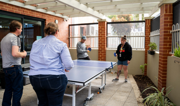 four people playing ping pong