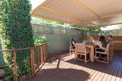 Three people at a table on a patio talking