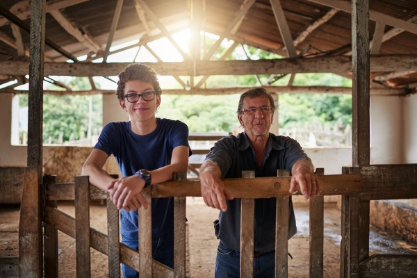 Father and son in a barn smiling