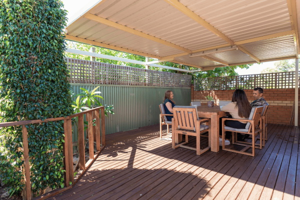 Outdoor patio with people sitting around a table talking