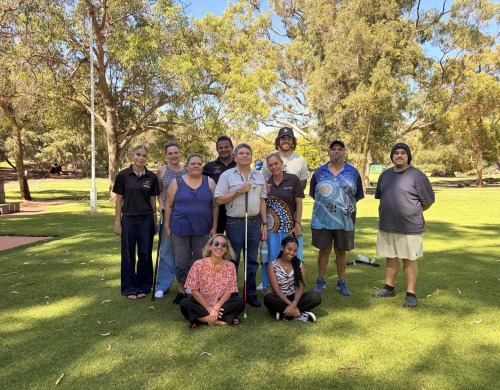 A group of people posing together on the grass in front of trees on the MDW tour