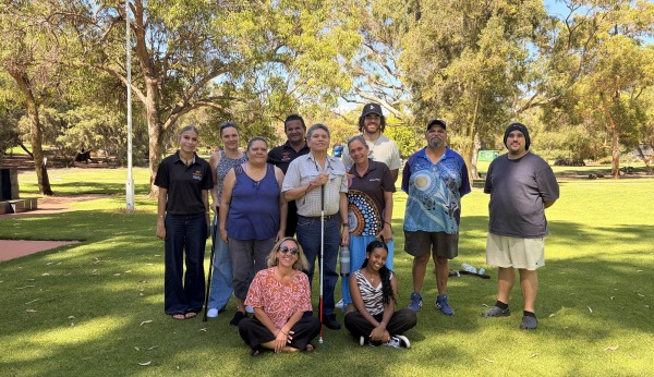 A group of people posing together on the grass in front of trees on the MDW tour