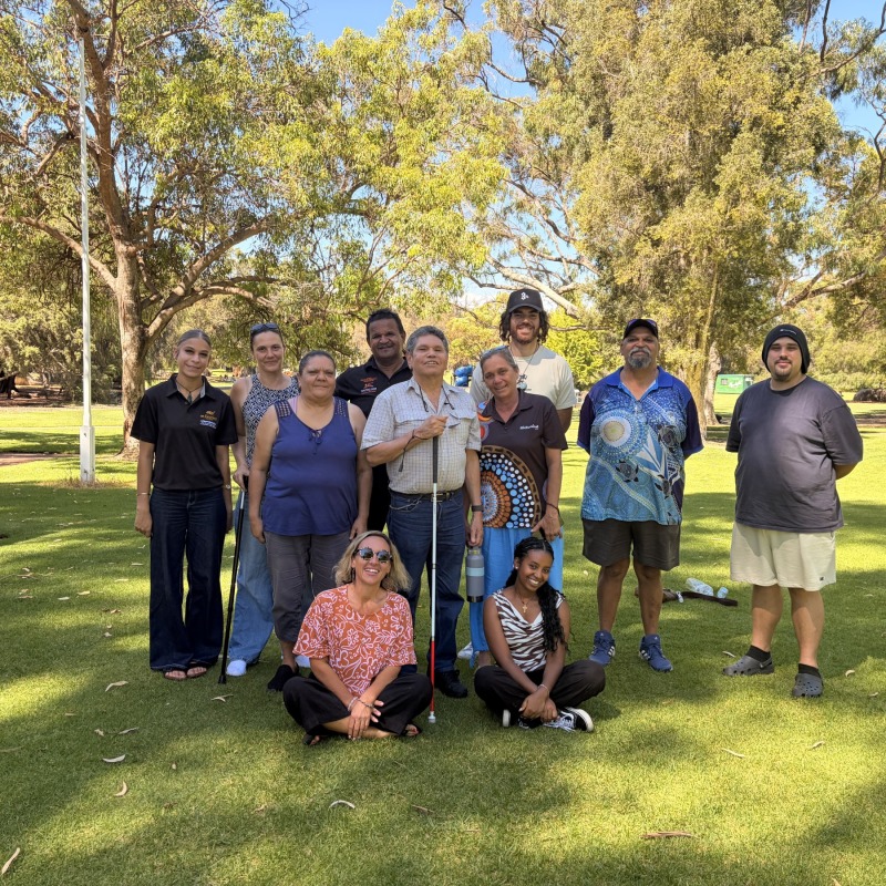 A group of people posing together on the grass in front of trees on the MDW tour